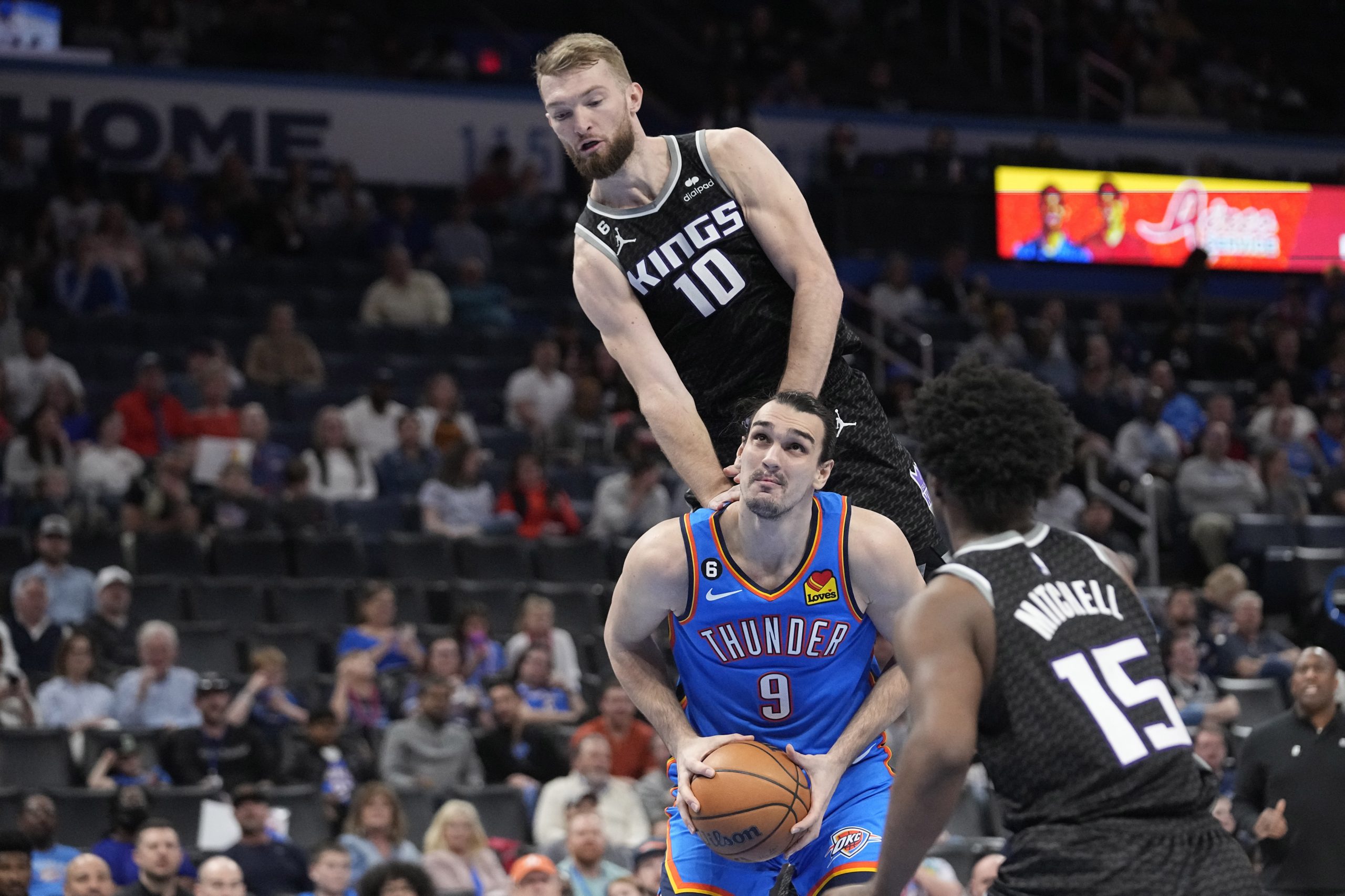 Oklahoma City Thunder forward Dario Saric (9) is fouled by Sacramento Kings forward Domantas Sabonis (10) in the second half of an NBA basketball game Tuesday, Feb. 28, 2023, in Oklahoma City. (AP Photo/Sue Ogrocki)