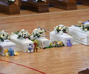 epa10496546 Toys placed near white coffins of the victims who died in a migrant shipwreck, at the Crotone Palasport, the funeral home for the victims, in Steccato di Cutro, Crotone Province, southern Italy, 01 March 2023. The death toll from a shipwreck off Calabria's coast in southern Italy rose to 67 on 01 March 2023, while three men were in detention accused of human trafficking, Italian officials said. A boat carrying migrants sank in rough seas near the Calabrian coast on 26 February.  EPA/CARMELO IMBESI