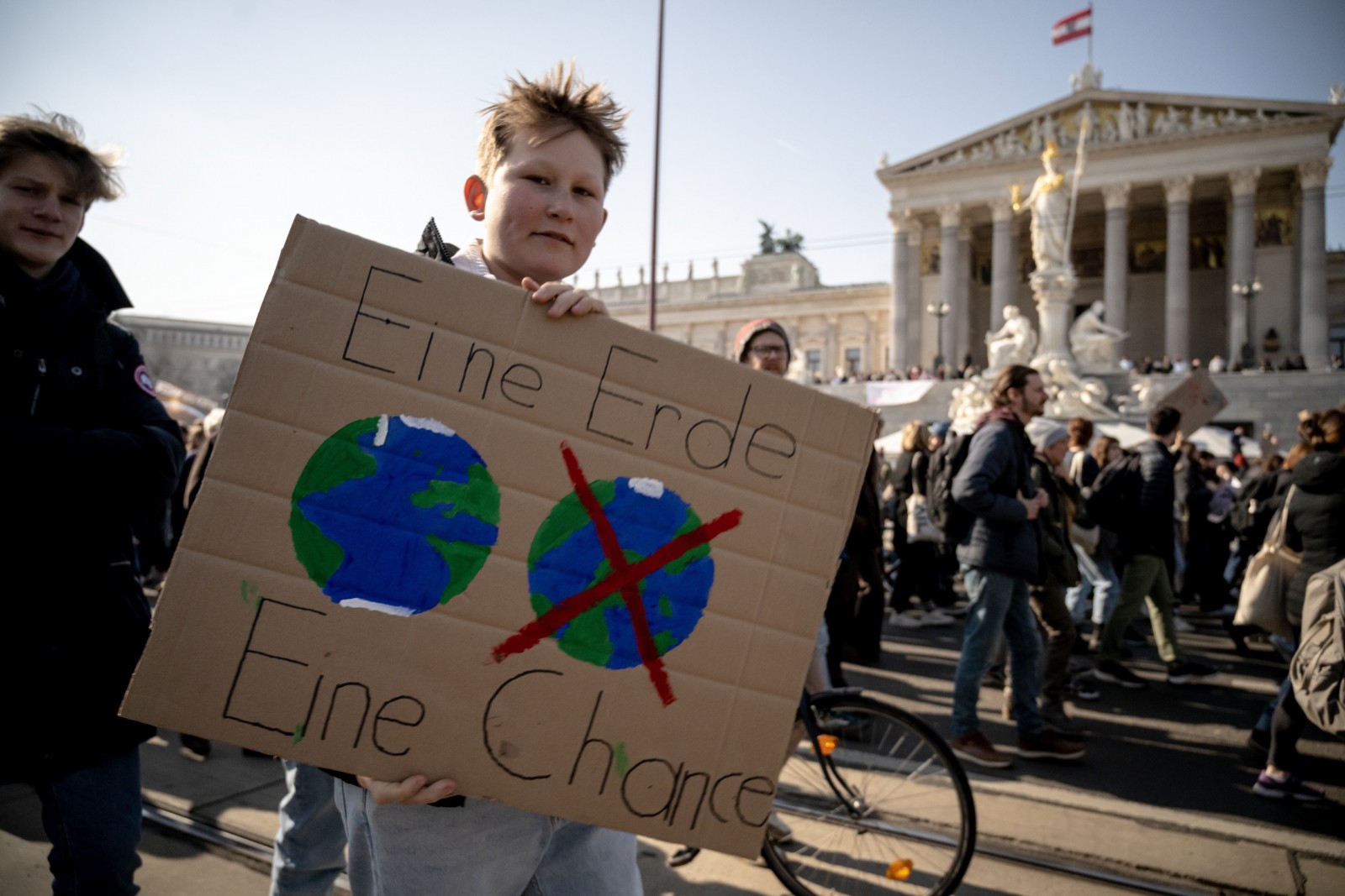 epa10500430 A protester holds a placard reading 'One Earth One Chance' during a Fridays for Future global climate strike demonstration in the city center of Vienna, Austria, 03 March 2023.  EPA/CHRISTIAN BRUNA