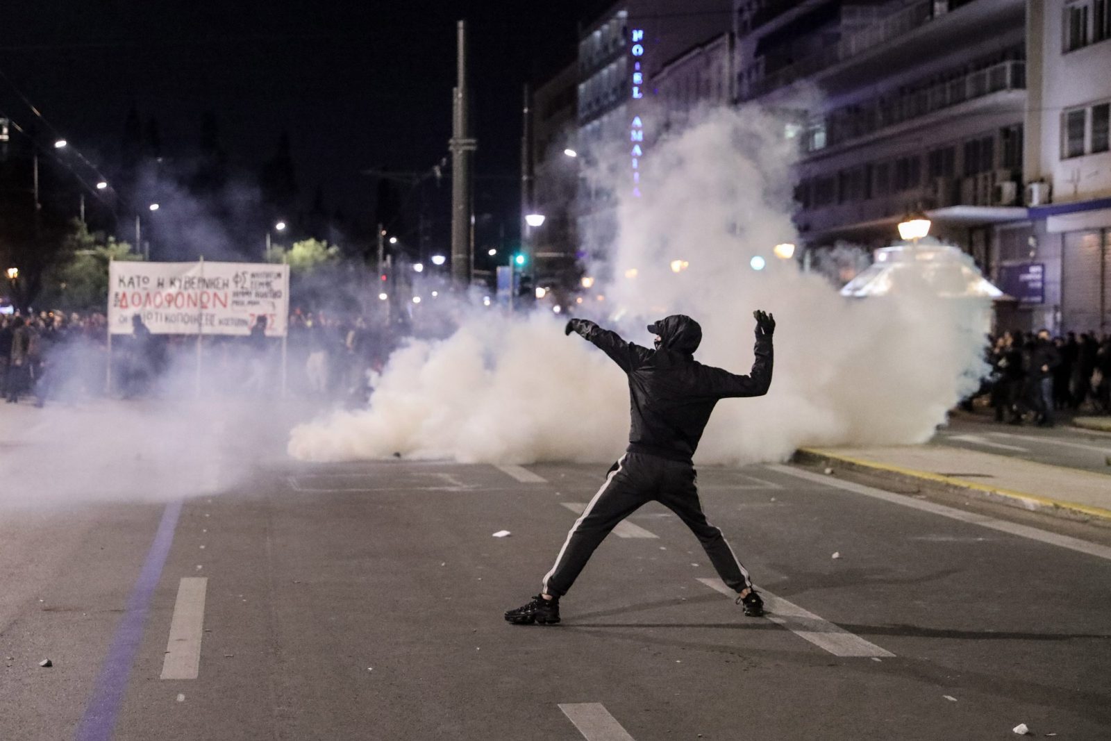 epa10501394 A protester hurls objects towards riot police during a protest over Greece's deadliest train crash, in front of Parliament in Athens, Greece, 03 March 2023. The death toll of the train collision that occurred on the Athens-Thessaloniki line has risen to 57, a Hellenic Police spokesperson confirmed on 02 March 2023. The collision between a passenger train traveling north and a freight train traveling south on the same line occurred on 28 February night.  EPA/GEORGE VITSARAS