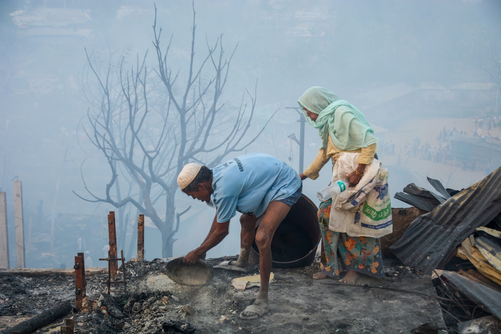epa10505474 Rohingya refugees search for their belongings after a fire broke out in Balukhali refugee camp in Ukhia, Cox’s bazar, Bangladesh, 05 March 2023. According to the United Nations High Commissioner for Refugees (UNHCR) report, over 90 facilities including hospitals and learning centres were damaged as a massive fire broke out at a Rohingya camp in Cox's Bazar's Ukhiya upazila on 05 March afternoon.  EPA/STR