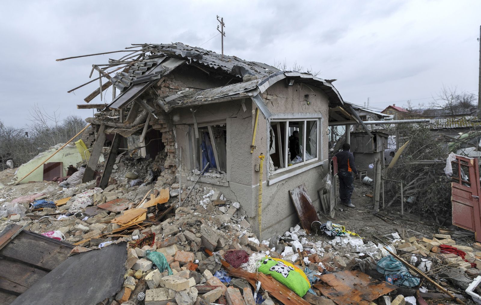 epa10511462 A Local man clears debris after two rocket's hit private buildings in the Zolochiv district near the Western Ukrainian city of Lviv, 09 March 2023. At least five people were killed during the attack according to regional official Maksym Kozytskyi. Ukrainian authorities said on 09 March that Russia fired 81 missiles across the country targeting critical infrastructure and residential buildings. The country's Defense Ministry confirmed that 34 cruise missiles were shot down. According to Ukraine's nuclear operator Energoatom, the Zaporizhzhia nuclear power plant (NPP) lost power as a result of the missile attacks, and was running on diesel generators.  EPA/MYKOLA TYS