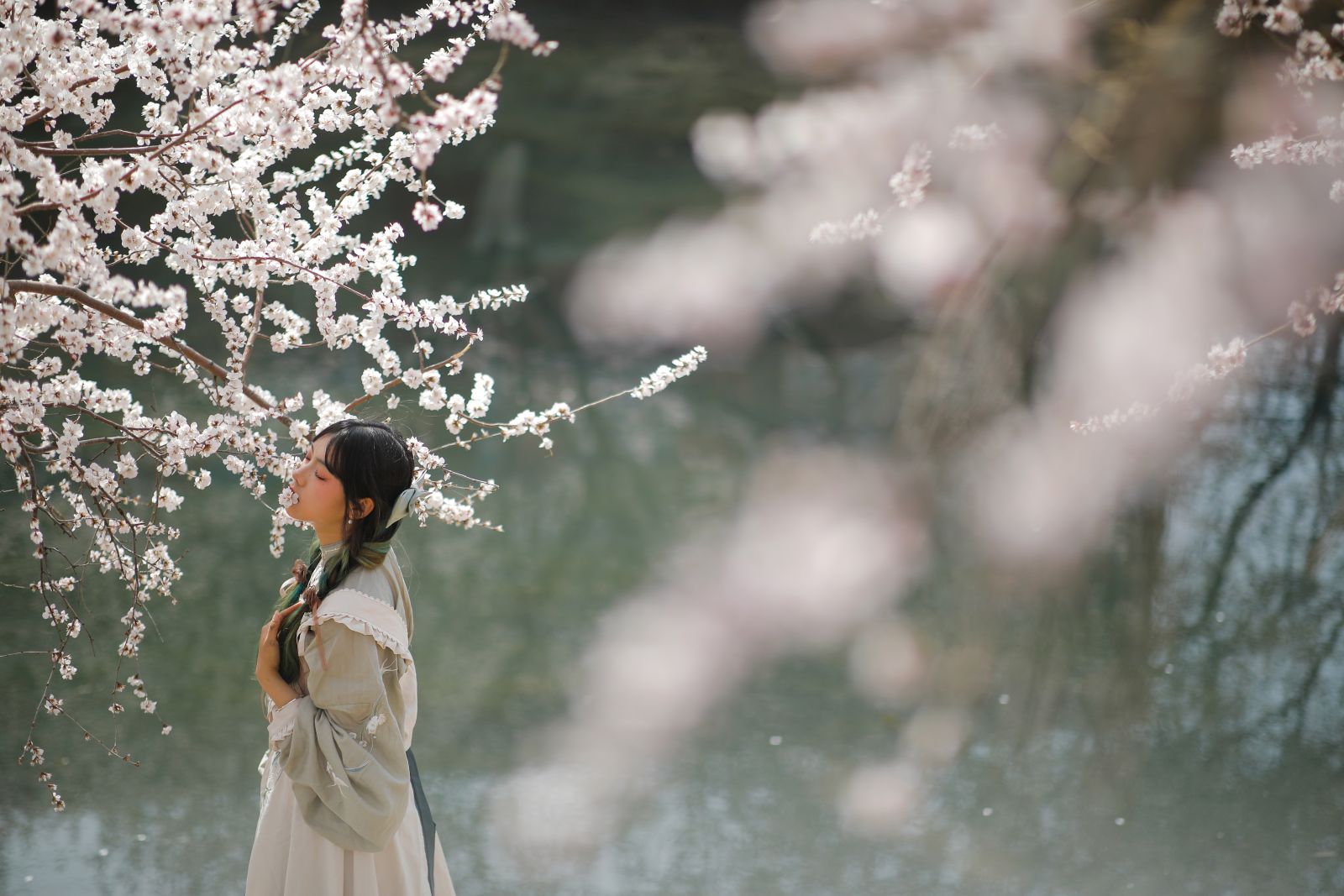 epa10513065 A woman poses for a photo in front of blossom peach trees in Beijing, China, 10 March 2023. Springtime in the Chinese capital from March to May is filled with colorful and fragrant blossoms. The diversity of the flowers in Beijing is attractive for visitors to take photos of them and spend good time in warm weather.  EPA/WU HAO