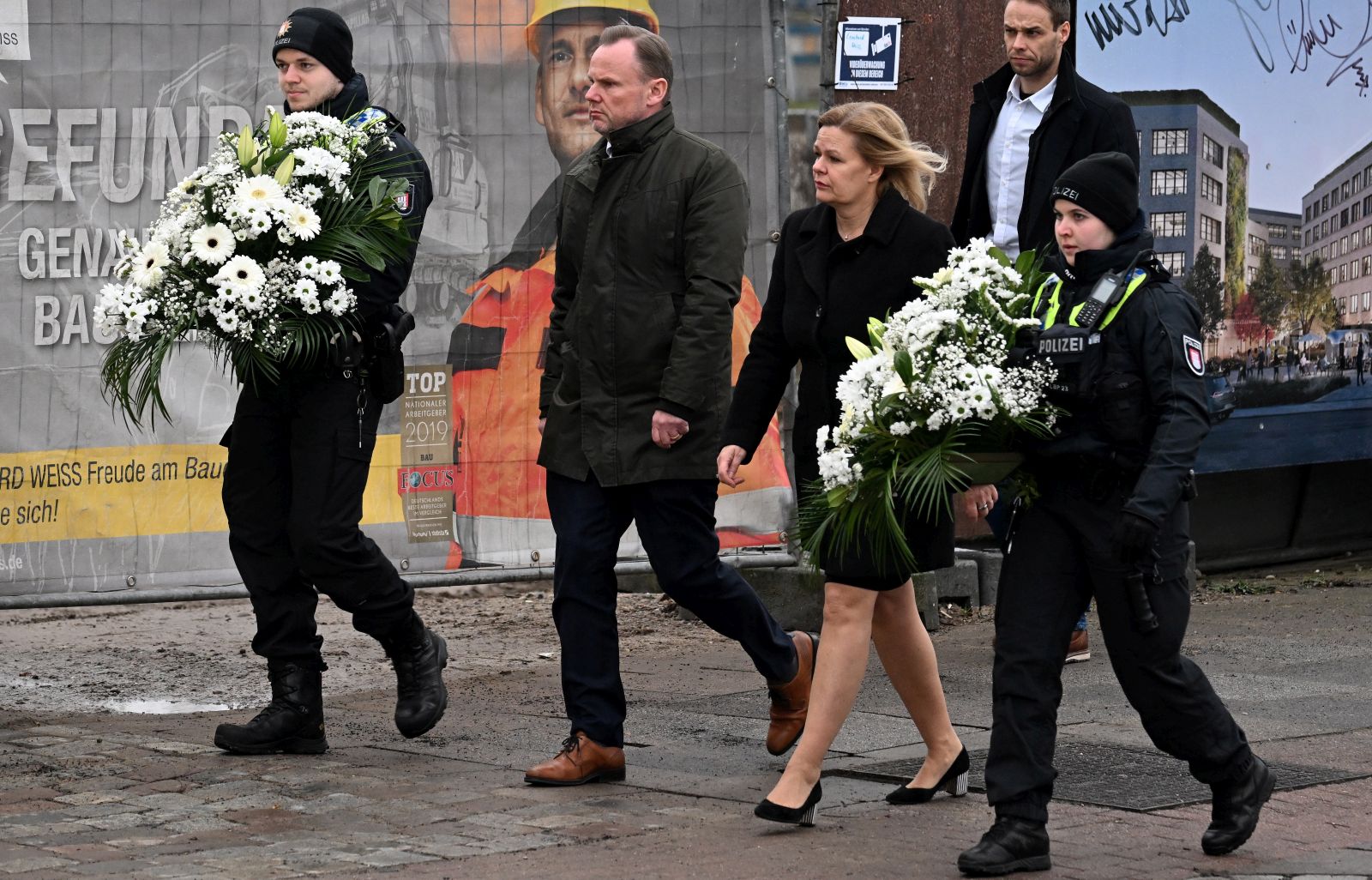 epa10513870 Hamburg Interior Senator Andy Grote (2-L) and German Interior minister Nancy Faeser (C) visit the scene of a shooting in Hamburg, Germany, 10 March 2023. According to Hamburg authorities, at least eight people died, including the suspected gunman, and eight others were injured in a shooting that occurred at a Jehovah's Witness meeting hall in the evening of 09 March. The police are investigating the motive of the incident.  EPA/FILIP SINGER