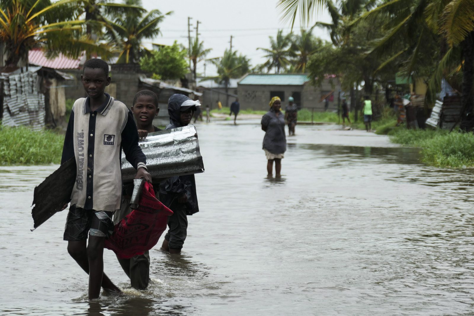 epa10515410 People walk on a flooded street near Quelimane, as the storm Freddy hits in Quelimane, Mozambique, 11 March 2023. The provincial capital of Quelimane will be the largest urban area closest to the cyclone's point of arrival on the mainland, and its radius (of about 300 kilometres) is expected to extend from Marromeu to Pebane, then moving inland towards Cherimane and southern Malawi. This is one of the longest lasting storms ever, after it formed at the beginning of February in the Asian seas, crossing the entire Indian Ocean to the east African coast.  EPA/ANDRÉ CATUEIRA