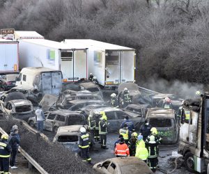 epa10515683 Firemen and police officers work among charred cars after 5 trucks and 37 cars crashed on M1 motorway near Herceghalom, Hungary, 11 March 2023. Twenty-six persons were injured, six of them critically, and nineteen vehicles burnt out.  EPA/Peter Lakatos HUNGARY OUT
