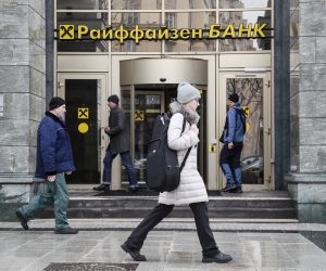 epa10526237 People walk in front of Raiffeisen bank in Moscow, Russia, 16 March 2023. Raiffeisen bank is discussing the exchange of Sberbank's European assets for its own in Russia. Raiffeisen Bank International (RBI) is considering exchange deal in Russia and Austria. Sberbank decided to leave the European market in March 2022, its banking license in the EU has expired, but due to sanctions, it cannot receive the proceeds from the procedure.  EPA/YURI KOCHETKOV