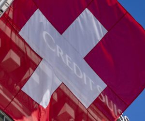 epa10526767 A Swiss national flag flies in front of the logo of Swiss bank Credit Suisse CS in Lucerne, Switzerland, 16 March 2023. Credit Suisse is borrowing up to 50 billion francs (50.8 billion euros) from the Swiss National Bank (SNB), according to a statement on 16 March 2023. This is intended to strengthen the group, whose shares have crashed on the stock exchange.  EPA/URS FLUEELER