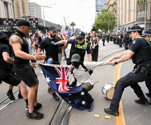 epaselect epa10529421 Police remove a protester during a transgender rights rally, involving opposing neo-Nazi protesters, outside Parliament House in Melbourne, Australia, 18 March 2023.  EPA/JAMES ROSS AUSTRALIA AND NEW ZEALAND OUT  
ALTERNATE CROP