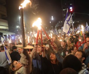 epa10530457 People light torches during a protest against the government's justice system reform plans in Tel Aviv, Israel, 18 March 2023. Nationwide protests against the government's judicial reform plans are being held for eleven weeks in a row. Israel's parliament passed a draft law limiting the power of the Israeli Supreme Court in a first reading on 14 March.  EPA/ABIR SULTAN