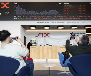 epa10533437 People take photos of a ticker showing the developments on UBS Group stock, among others, at SIX Swiss Exchange in Zurich, Switzerland, 20 March 2023. Financial markets are reacting after troubled bank Credit Suisse was rescued in a three billion dollars purchase by its Swiss rival UBS in a government-backed deal. UBS is down 13 percent and other European bank shares have also dropped significantly.  EPA/ENNIO LEANZA