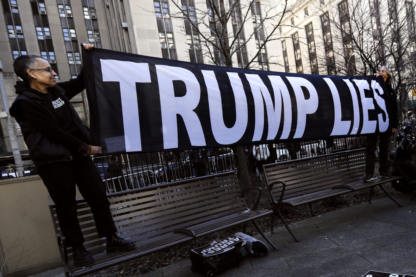 epaselect epa10535539 Demonstrators hold up a banner outside New York Criminal Court in advance of a potential Indictment of Former President Donald Trump in New York, New York, USA, 21 March 2023. Major US News organizations continue to report the likelihood that former President Donald J. Trump may be the first US President to be formally indicted on charges related to hush-money payments to porn star Stormy Daniels.  EPA/Peter Foley