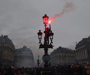 epa10539134 A protester lights a flair as thousands of people participate in a protest against the government's reform of the pension system in Paris, France, 23 March 2023. Protests continue in France after the prime minister announced on 16 March 2023 the use of Article 49 paragraph 3 (49.3) of the French Constitution to have the text on the controversial pension reform law - raising retirement age from 62 to 64 - be definitively adopted without a vote.  EPA/MOHAMMED BADRA