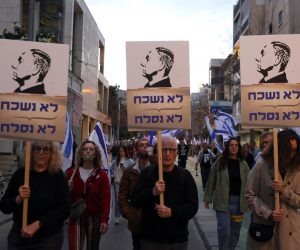 epa10542840 Protesters with placards of Israeli Prime Minister Netanyahu with Hebrew slogan 'We will not forget, we will not forgive' during a march against government's justice system reform plans in Tel Aviv, Israel, 25 March 2023. Nationwide anti-government protests have been sparked by Israeli government plans to reform the justice system and limit the power of the Supreme Court.  EPA/ABIR SULTAN