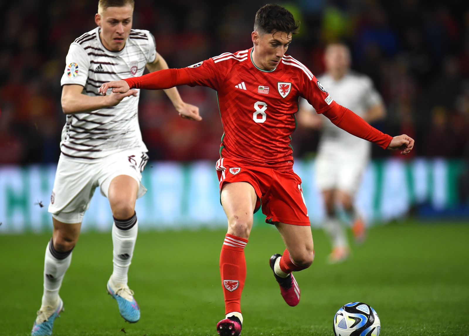 epa10547646 Harry Wilson (R) of Wales in action against Kristers Tobers
 of Latvia during the UEFA EURO 2024 qualification match between Wales and Latvia in Cardiff, Britain, 28 March 2023.  EPA/Peter Powell