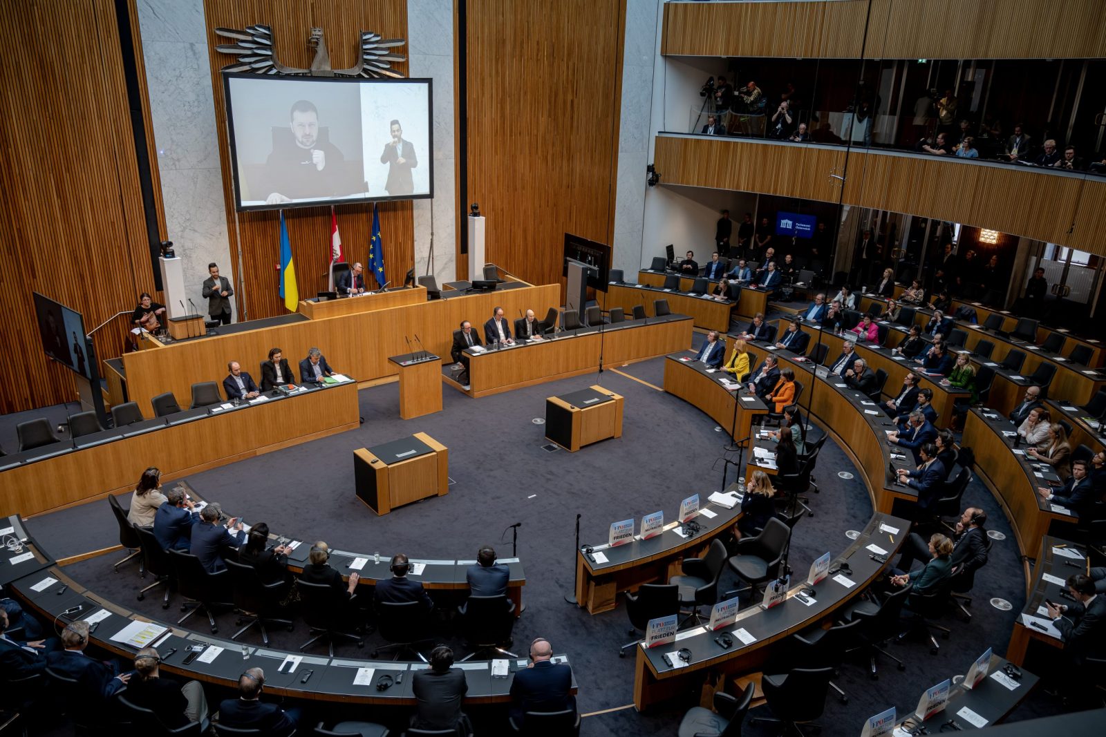 epa10550004 Austrian MPs listen to Ukraine's President Volodymyr Zelensky's video address during a session of the Austrian National Council at the historic Austrian parliament building in Vienna, Austria, 30 March 2023. It is the first time the Ukrainian head of state addresses the Austrian parliament.  EPA/CHRISTIAN BRUNA