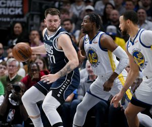 Mar 22, 2023; Dallas, Texas, USA; Dallas Mavericks guard Luka Doncic (77) looks to move the ball past Golden State Warriors forward Jonathan Kuminga (00) and guard Stephen Curry (30) during the first quarter at the American Airlines Center. Mandatory Credit: Jerome Miron-USA TODAY Sports Photo: Jerome Miron/REUTERS