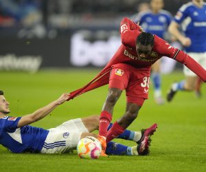 Schalke's Tom Krauss, left, and Leverkusen's Jeremie Frimpong challenge for the ball during the German Bundesliga soccer match between Schalke 04 and Bayer Leverkusen in Gelsenkirchen, Germany, Saturday, April 1, 2023. (AP Photo/Martin Meissner)