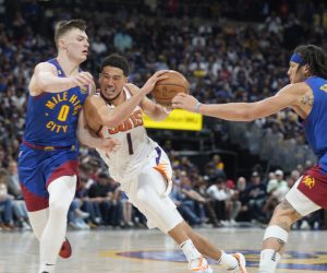 Phoenix Suns guard Devin Booker, center, drives the lane as Denver Nuggets guard Christian Braun, left, and forward Aaron Gordon defend in the second half of Game 1 of an NBA second-round basketball series Saturday, April 29, 2023, in Denver. (AP Photo/David Zalubowski)