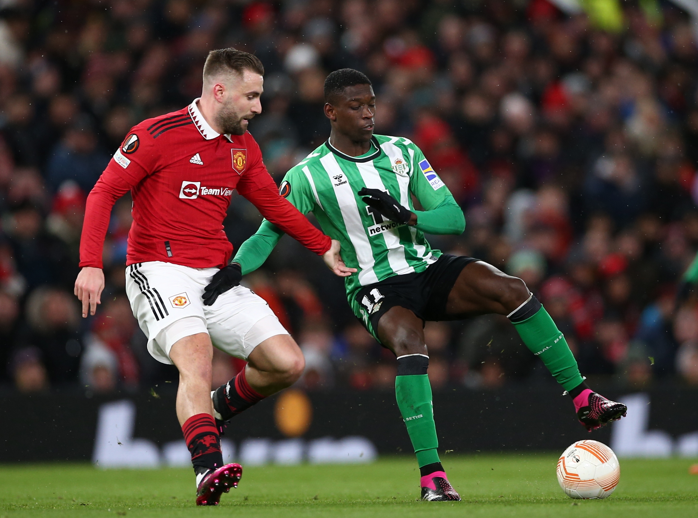 epa10512296 Luke Shaw (L) of Manchester United in action against Luiz Henrique of Real Betis during the UEFA Europa League Round of 16, 1st leg match between Manchester United and Real Betis in Manchester, Britain, 09 March 2023.  EPA/Adam Vaughan