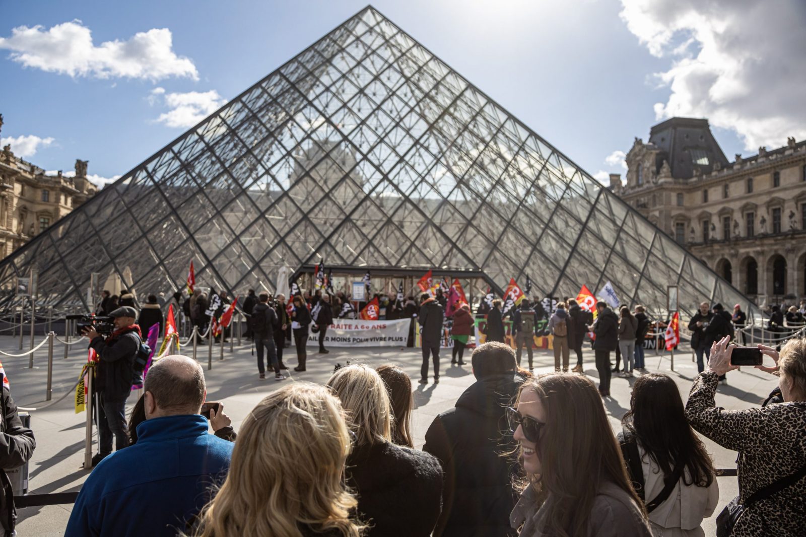 epa10545203 Visitors wait outside the Louvre Museum as its employees block entrance during a demonstration to protest against the government's pension reform in Paris, France, 27 March 2023. France faces an ongoing national strike against the government's pensions reform after Prime Minister Elisabeth Borne on 16 March announced the use of article 49 paragraph 3 (49.3) of the Constitution of France to have the text on the controversial pension reform law to be definitively adopted without a vote.  EPA/CHRISTOPHE PETIT TESSON