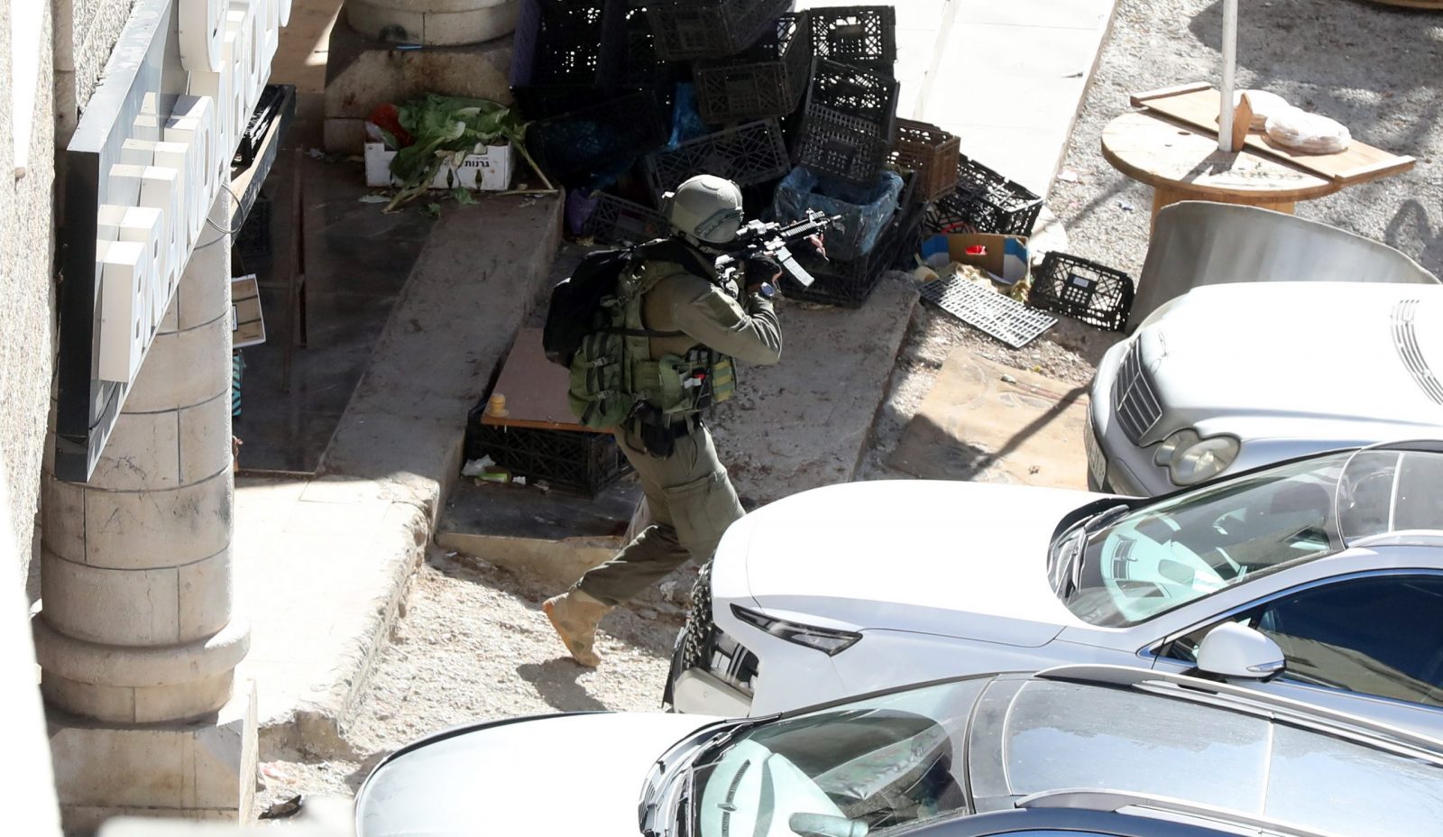 epa10556539 An Isaeli soldier takes position during an operation in the West Bank City of Nablus, 03 April 2023. Two Palestinians were killed and 20 wounded during an Israeli army raid in Nablus city early Monday 03 April, Palestinian health Ministry said.  EPA/ALAA BADARNEH