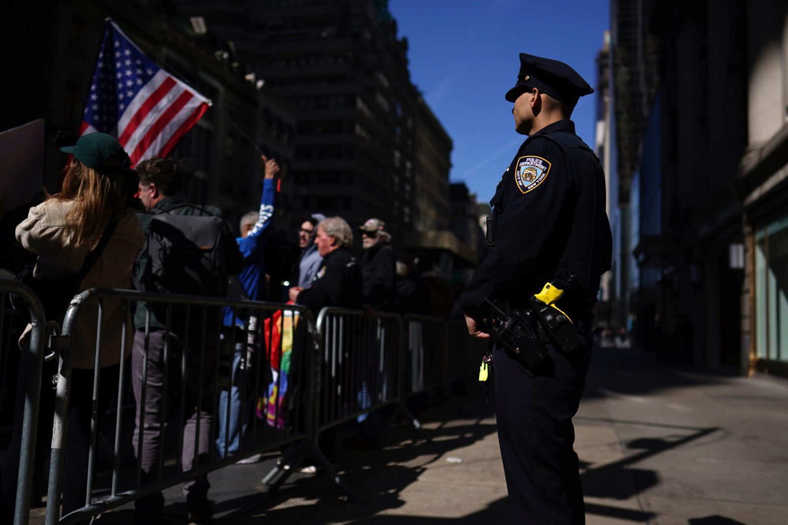 epa10557479 A police officer watches supporters of former US president Donald J. Trump stand near Trump Tower in New York, New York, USA, 03 April 2023. After being indicted by a Manhattan grand jury last week, Trump traveled to New York and will reportedly turn himself in on 04 April at New York Criminal Court to hear the charges against him.  EPA/WILL OLIVER