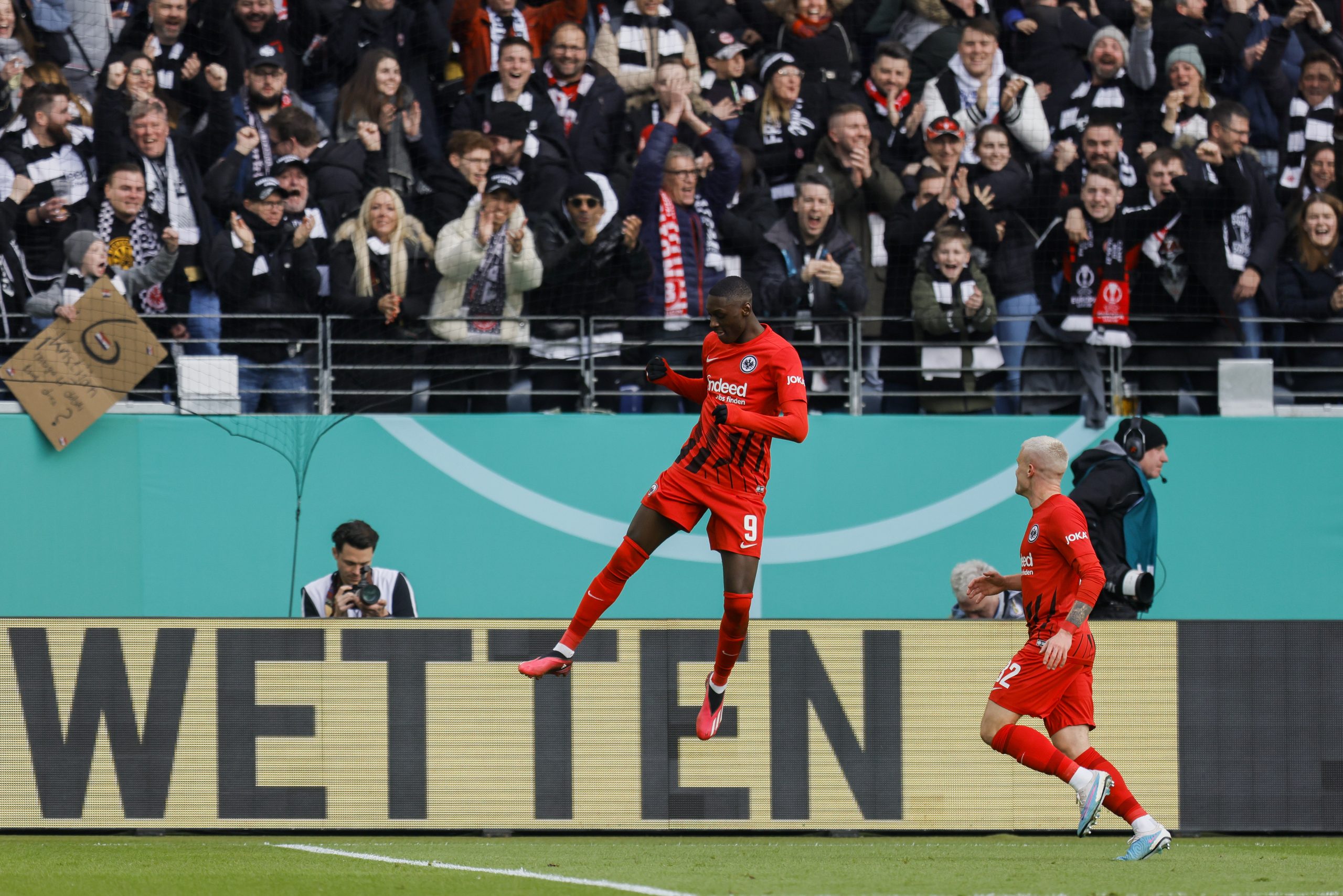 epa10558406 Randal Kolo Muani of Eintracht Frankfurt celebrates with team mates after scoring a goal during the German DFB Cup quarter final soccer match between Eintracht Frankfurt and 1. FC Union Berlin in Frankfurt, Germany, 04 April 2023.  EPA/RONALD WITTEK CONDITIONS - ATTENTION: The DFB regulations prohibit any use of photographs as image sequences and/or quasi-video.