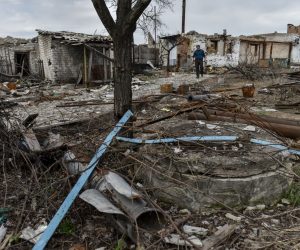 epa10560322 A man collects metal in his yard, destroyed in combat action, in Liskivka village, Donetsk Region, Ukraine, 05 April 2023. Russian troops entered Ukrainian territory on 24 February 2022, starting a conflict that has provoked destruction and a humanitarian crisis.  EPA/OLEG PETRASYUK