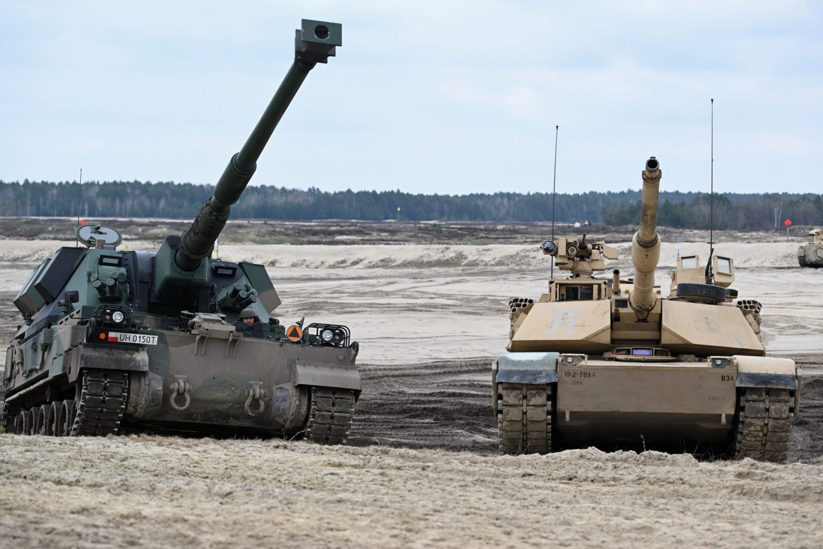 epa10569707 Abrams tank (R) and Krab self-propelled cannon howitzer (L) during the training of Polish and American soldiers at the training ground in Nowa Deba, southeast Poland, 12 April 2023.  EPA/Darek Delmanowicz POLAND OUT
