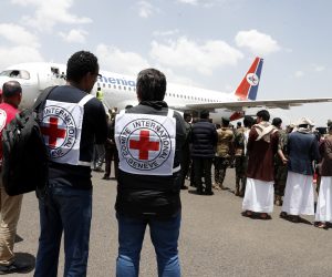 epa10572345 ICRC members stand near a plane carrying freed prisoners loyal to Houthis upon their arrival at Sanaa Airport, on the first day of a prisoner swap, in Sana'a, Yemen, 14 April 2023. According to the International Committee of the Red Cross (ICRC), Yemen's warring parties began on 14 April a three-day exchange of 887 prisoners. The Houthis have agreed to release 181 detainees, including Saudis and Sudanese soldiers who fought alongside Yemeni government forces, in exchange for 706 prisoners held by the Yemeni government, under the UN and ICRC-brokered prisoner swap deal reached last March in Switzerland.  EPA/YAHYA ARHAB