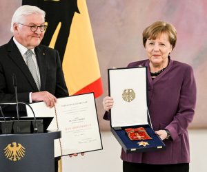 epa10577208 Former German Chancellor Angela Merkel (R) poses with the box after she was awarded the 'Grand Cross of the Order of Merit of the Federal Republic of Germany' by German President Frank-Walter Steinmeier (L) during a ceremony in Berlin, Germany, 17 April 2023.  EPA/FILIP SINGER