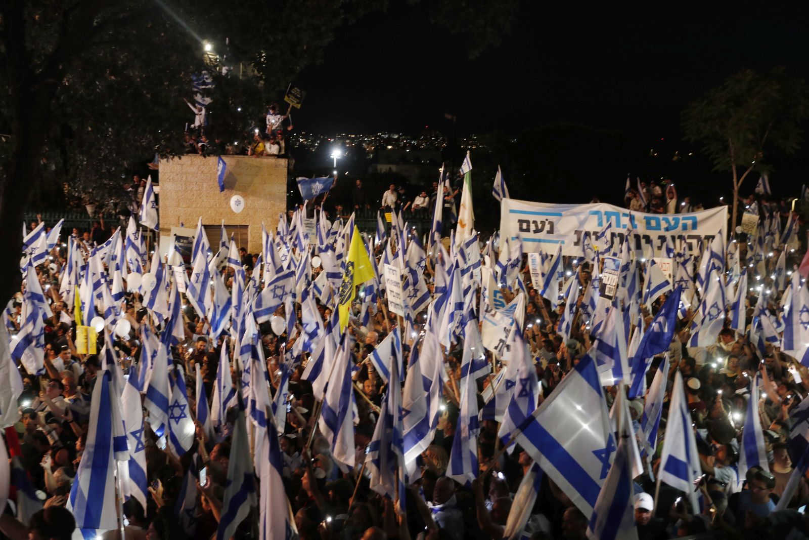epa10594981 Israeli right-wing government supporters rally outside the Israeli Knesset in Jerusalem, in support of the government, 27 April 2023. The protesters called to implement the government's plans to reform the justice system and limit the power of the Israeli Supreme Court.  EPA/ATEF SAFADI