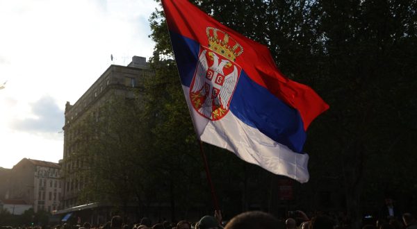 epa10615781 A man waves a Serbian flag during a protest in Belgrade, Serbia, 08 May 2023. Opposition political parties have called on a peaceful and silent protest against violence in Serbian society following two mass shootings.  EPA/ANDREJ CUKIC