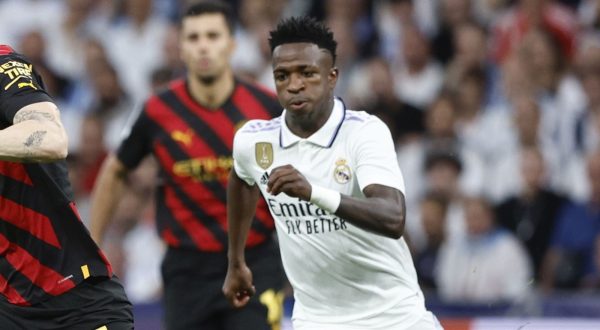 epa10617965 Real Madrid's striker Vinicius Jr (R) in action against Manchester City's midfielder John Stones (C) during the UEFA Champions League semifinal first leg soccer match between Real Madrid and Manchester City at Santiago Bernabeu Stadium, in Madrid, Spain, 09 May 2023.  EPA/Rodrigo Jimenez