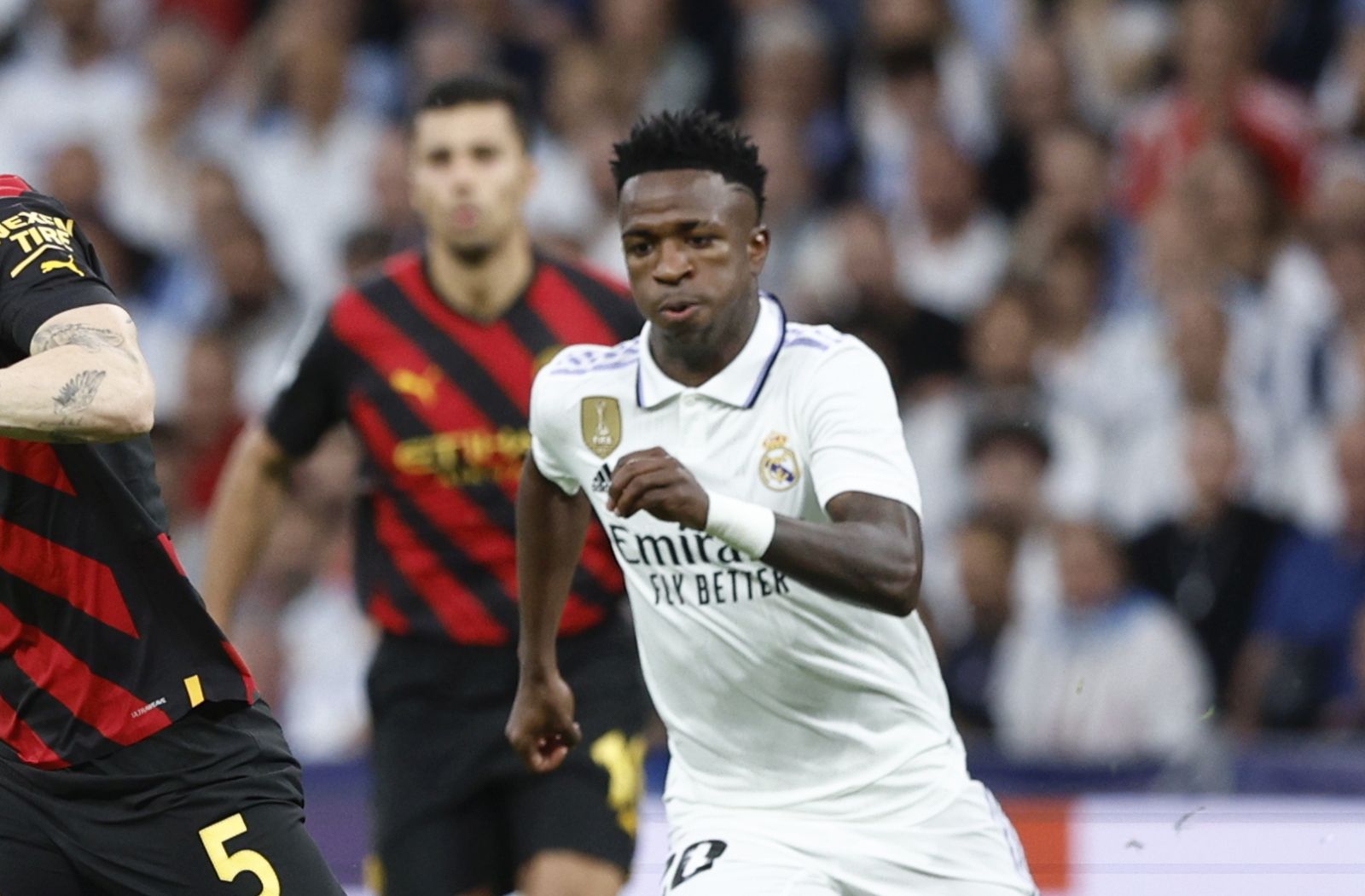 epa10617965 Real Madrid's striker Vinicius Jr (R) in action against Manchester City's midfielder John Stones (C) during the UEFA Champions League semifinal first leg soccer match between Real Madrid and Manchester City at Santiago Bernabeu Stadium, in Madrid, Spain, 09 May 2023.  EPA/Rodrigo Jimenez