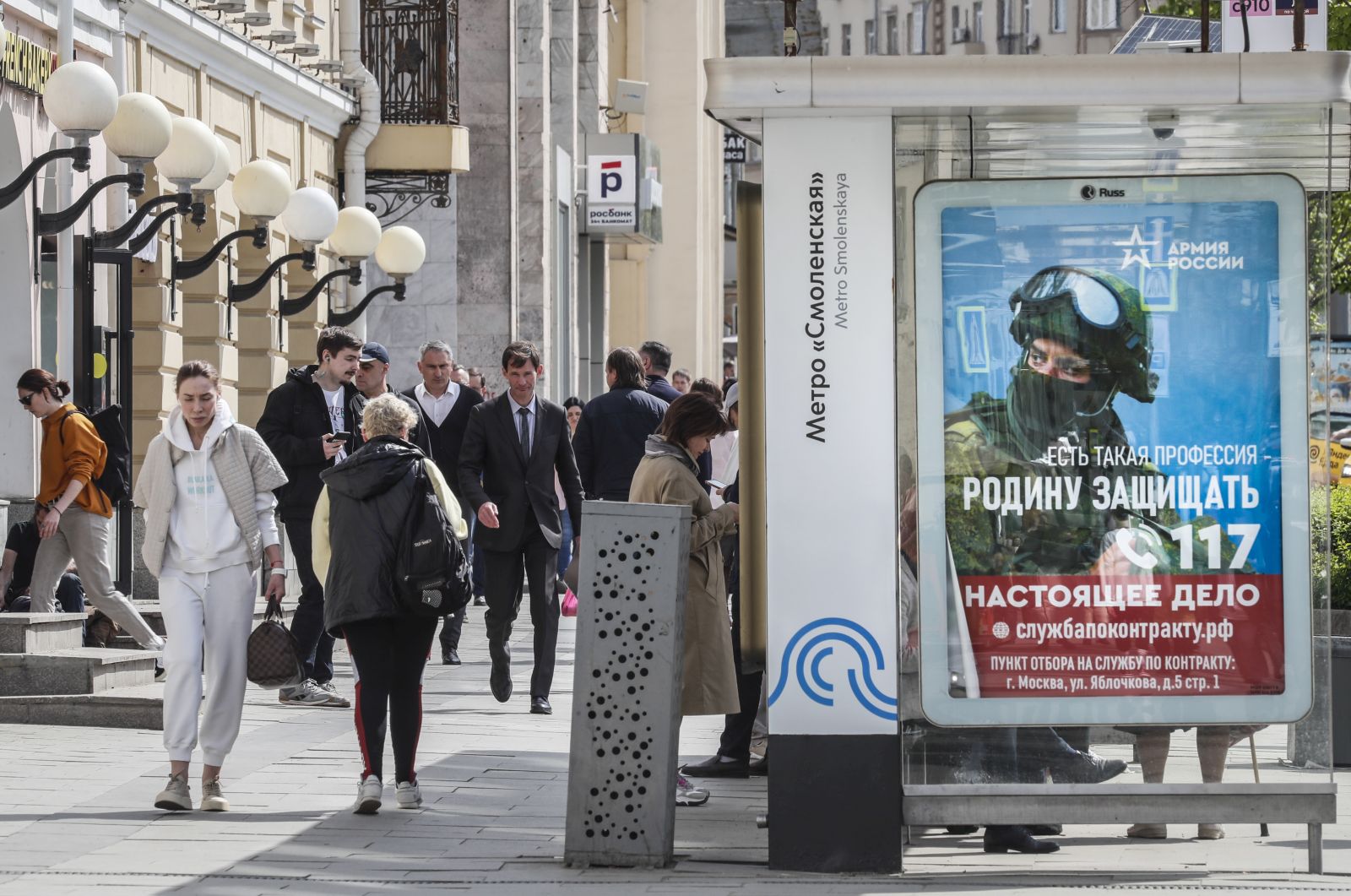 epa10623095 People walk past a poster with a proposal to serve on a contract in the Armed Forces of the Russian Federation in Moscow, Russia, 12 May 2023. On 24 February 2022 Russian troops entered Ukrainian territory in what the Russian president declared as a 'Special Military Operation', starting an armed conflict.  EPA/YURI KOCHETKOV
