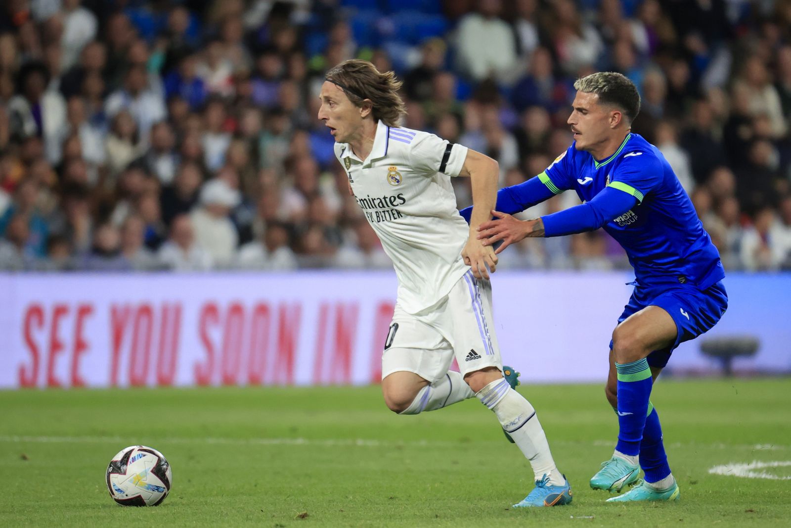 epa10626201 Real Madrid's midfielder Luka Modric (L) duels for the ball with Getafe's midfielder Jaime Seoane (R) during the Spanish LaLiga soccer match between Real Madrid and Getafe CF at Santiago Bernabeu Stadium in Madrid, Spain, 13 May 2023.  EPA/ZIPI ARAGON