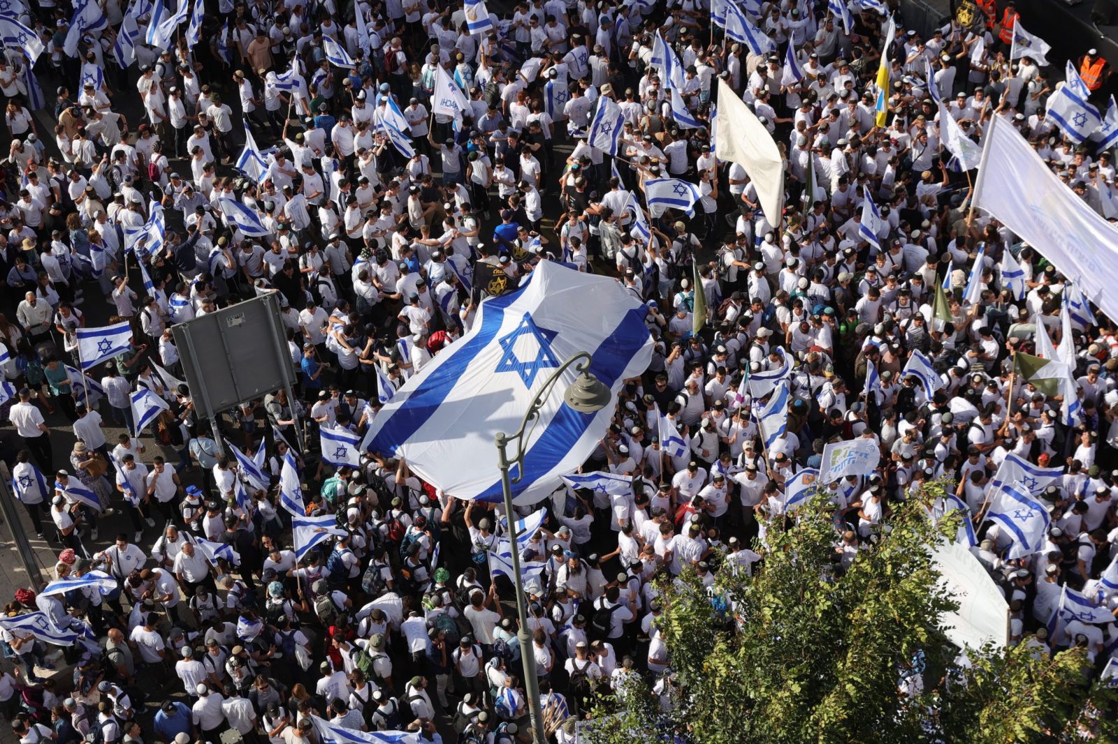 epa10636732 Participants dance and carry Israeli flags during the Israeli right-wing 'Flag March' in Jerusalem, 18 May 2023. The annual right-wing Israeli 'Flag March' commemorates the establishment of Israeli control over the Old City of Jerusalem after the six-day war in 1967. Celebrating Jerusalem Day has long been viewed by Palestinians as a provocation.  EPA/ABIR SULTAN