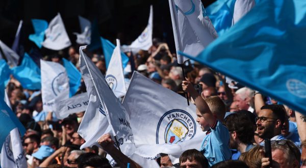 epa10643851 Manchester City's fans wave flags during the English Premier League soccer match between Manchester City and Chelsea at the Etihad in Manchester, Britain, 21 May 2023.  EPA/Peter Powell EDITORIAL USE ONLY. No use with unauthorized audio, video, data, fixture lists, club/league logos or 'live' services. Online in-match use limited to 120 images, no video emulation. No use in betting, games or single club/league/player publications