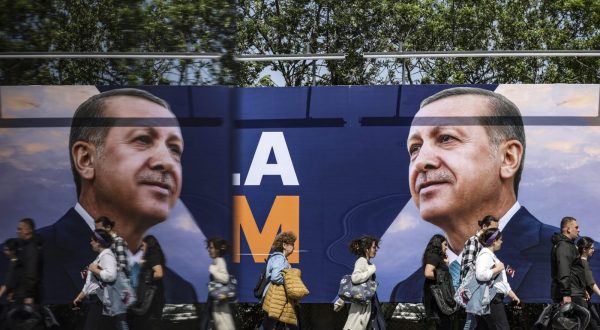 epa10646259 People walk in front of an election campaign poster of Turkish President Recep Tayyip Erdogan, in Istanbul, Turkey, 22 May 2023. General elections had been held in Turkey on 14 May, where none of the candidates exceeded the 50 percent mark in the first round. The second round of presidential elections between Turkish President Recep Tayyip Erdogan and his challenger Kemal Kilicdaroglu, the leader of the opposition Republican People's Party (CHP), will be held on 28 May.  EPA/ERDEM SAHIN