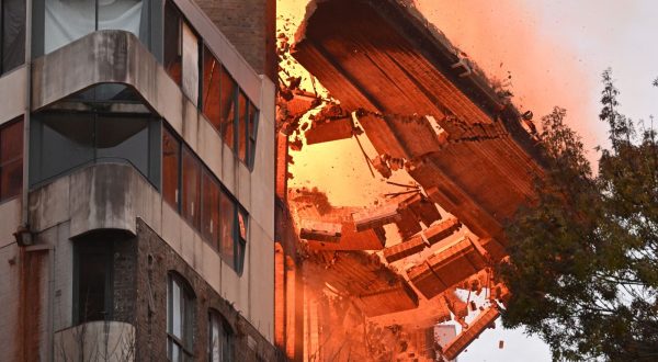 epa10652049 A wall collapses during a building fire in the Central Business District of Sydney, Australia, 25 May 2023. Fire and Rescue New South Wales said more than 100 firefighters were deployed to the area to battle the fire that erupted in the seven-storey building.  EPA/DEAN LEWINS AUSTRALIA AND NEW ZEALAND OUT