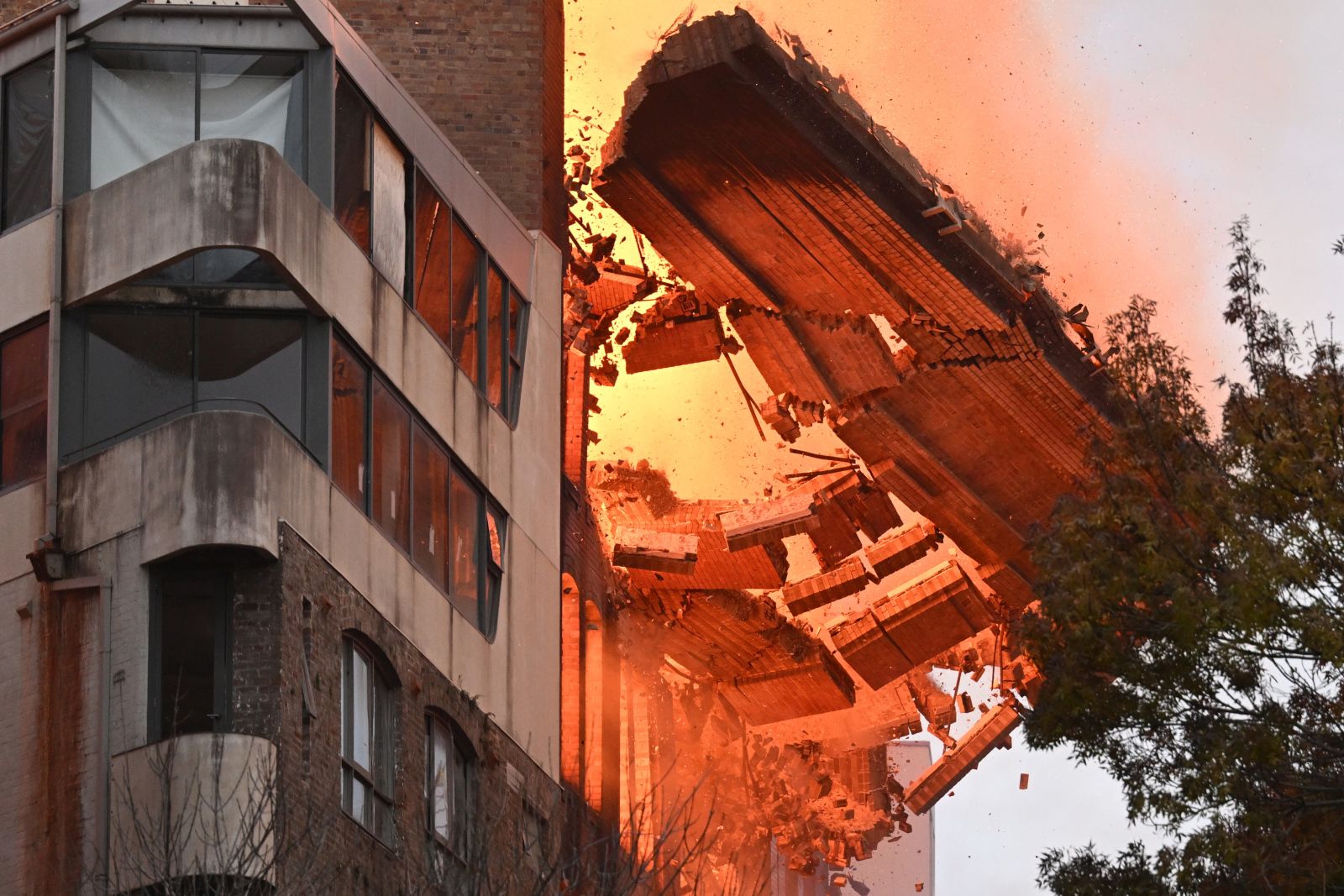 epa10652049 A wall collapses during a building fire in the Central Business District of Sydney, Australia, 25 May 2023. Fire and Rescue New South Wales said more than 100 firefighters were deployed to the area to battle the fire that erupted in the seven-storey building.  EPA/DEAN LEWINS AUSTRALIA AND NEW ZEALAND OUT