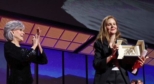 epa10658717 Justine Triet (C) is applauded by US acrtress Jane Fonda (L) as she holds the Palme D'Or Award for her movie 'Anatomy of a Fall' during the Closing Ceremony of the 76th annual Cannes Film Festival, in Cannes, France, 27 May 2023.  EPA/MOHAMMED BADRA