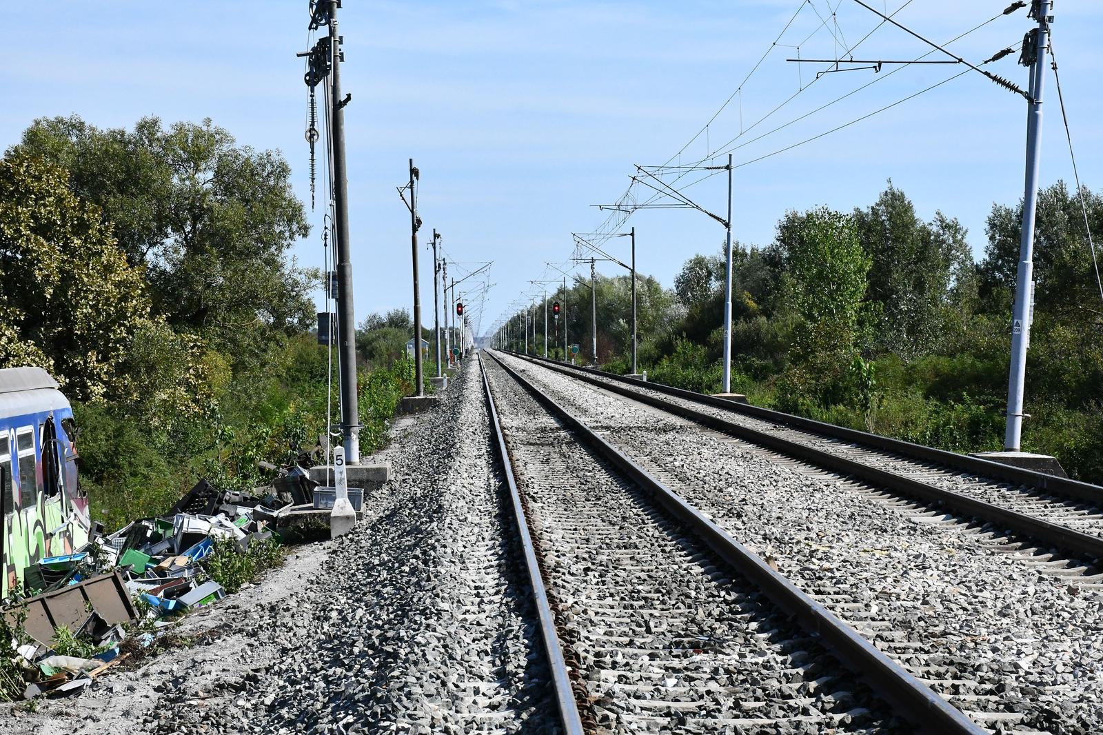 13.09.2022., Rajic, Novska - Na mjestu sudara vlakova u Rajicu uspostavljen je promet, ali samo juznim kolosijekom.  Na sjevernom kolosijeku radnici HZ-a uspostavljaju elektricne vodove. Olupina putnickog vlaka i dijelovi teretnih vagona cekaju specijalnu dizalicu i transport s mjesta nesrece. Photo: Ivica Galovic/PIXSELL Photo: Ivica Galovic/PIXSELL