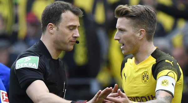Referee Felix Zwayer talks to Dortmund's Marco Reus after he he gave him a red card during the German Bundesliga soccer match between Borussia Dortmund and FC Schalke 04 in Dortmund, Germany, Saturday, April 27, 2019. Dortmund was defeated in the Derby by Schalke with 2-4. (AP Photo/Martin Meissner)