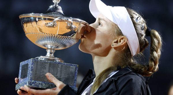 epa10642252 Elena Rybakina of Kazakhstan kisses the trophy after winning her women's singles final match against Anhelina Kalinina of Ukraine  during the Italian Open tennis tournament in Rome, Italy, 20 May 2023.  EPA/FABIO FRUSTACI