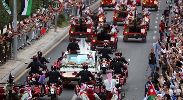 epa10667306 Jordanian Crown Prince Hussein (C-L) and his wife, Princess Rajwa Al Saif (C-R), of Saudi Arabia, wave to people lining the street during a wedding parade after their royal wedding ceremony in Amman, Jordan 01 June 2023. The wedding was held at Zahran Palace attended by Jordan's king and queen, the parents of the bride, and international royals and heads of state.  EPA/MOHAMMAD ALI