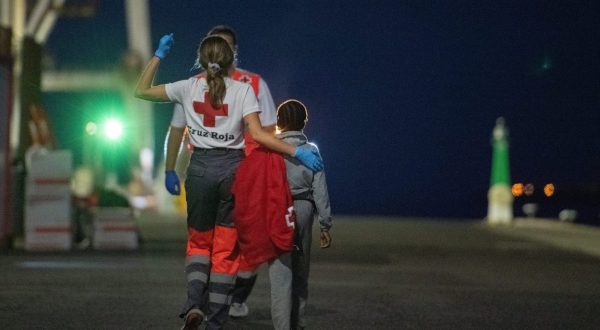 epa10675310 A Red Cross member takes care of a migrant girl after a Spanish sea rescue ship arrived in port with 57 migrants on board, at the port in Puerto del Rosario, Fuerteventura island, Canary Islands, southwestern Spain, late 05 June 2023 (issued on 06 June 2023). Spanish authorities rescued 57 migrants, including six women and a girl, found on board a boat off eastern Fuerteventura coast.  EPA/Carlos de Saa