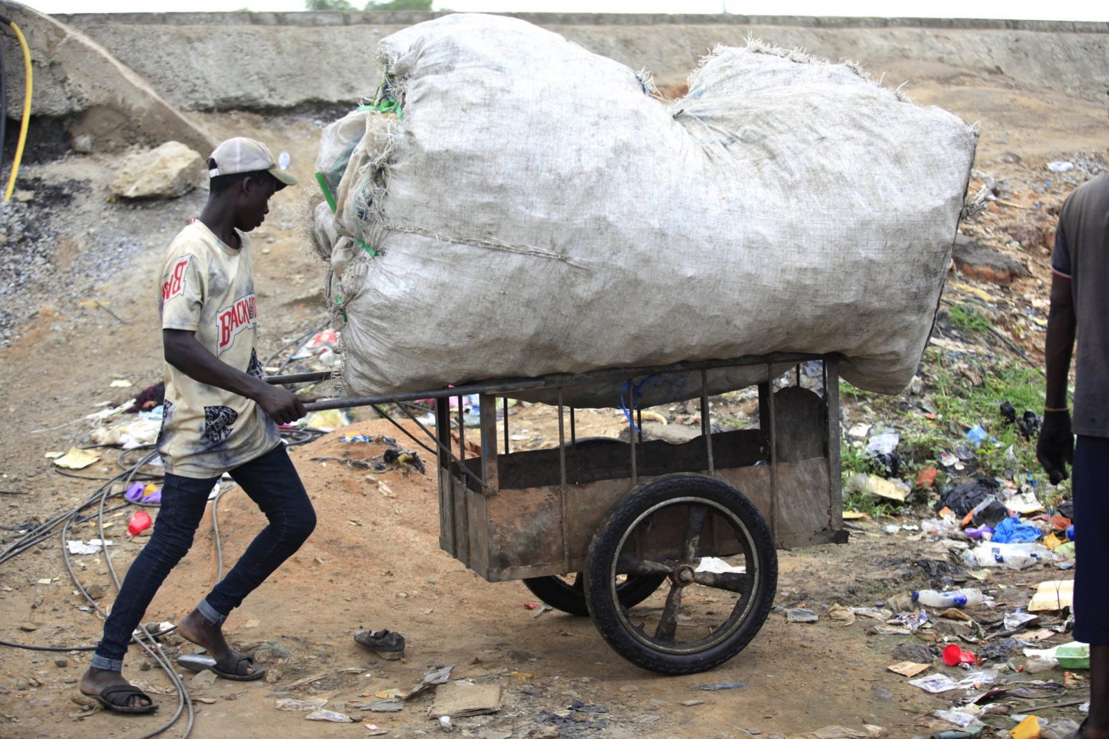 epa10674777 A man pushes a cart loaded with a sack filled up with used plastics for recycling, at a dumpsite along the Lagos-Ibadan expressway in Lagos, Nigeria, 05 June 2023. The World marks the 2023 Environment Day on 05 June with a focus on 'solutions to plastic pollution'.  EPA/AKINTUNDE AKINLEYE  ATTENTION: This Image is part of a PHOTO SET